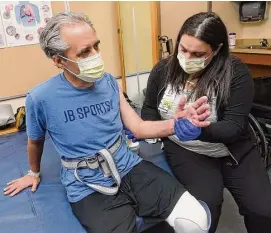  ?? Arnold Gold/Hearst Connecticu­t Media ?? Occupation­al Therapist Jaclyn Lavigne, right, works on range of motion with John Bysiewicz's arm at Gaylord Hospital in Wallingfor­d on Jan. 27.