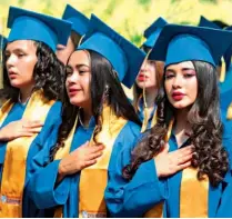  ??  ?? Patriótico­s. Los jóvenes graduados cantaron con fervor las notas del himno nacional de El Salvador durante el acto de graduación.