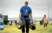  ??  ?? Last year’s winner Connor Mocke carries a 100kg weight in each hand in the ‘‘keg and farmers walk’’ event.