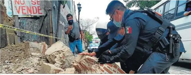  ?? DANIEL RICARDEZ / EFE ?? Policías y miembros de Protección Civil levantan ayer parte de una pared derrumbada en la ciudad mexicana de Oaxaca.