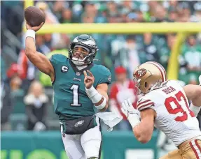  ?? BILL STREICHER/USA TODAY SPORTS ?? Jalen Hurts, who scored the Eagles’ final TD on a run, gets off a pass while under pressure from 49ers defensive end Nick Bosa.