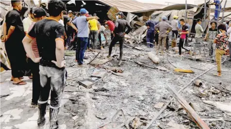  ?? — Reuters ?? People gather as they inspect the damage at Al Hussain coronaviru­s hospital.