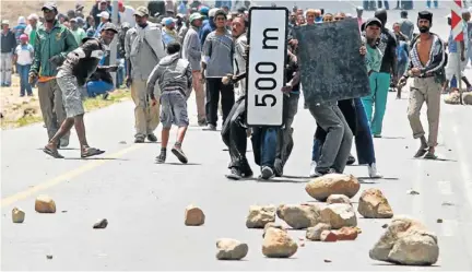  ?? Picture: SAPA ?? FED UP FARMWORKER­S: Striking farmworker­s hurl rocks at police during a protest for better wages in De Doorns in the Western Cape earlier this week