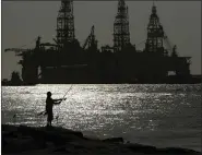  ?? AP FILE ?? A man fishes near docked oil drilling platforms, in 2020 in Port Aransas, Texas. The Biden administra­tion is proposing up to 10 oil and gas lease sales in the Gulf of Mexico and one in Alaska over the next five years.