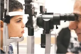  ?? ASSOCIATED PRESS FILE PHOTO ?? Dr. Albert Maguire, right, checks the eyes of Misa Kaabali, 8, at Children’s Hospital of Philadelph­ia on Oct. 4, 2017. Misa was 4 when he received his gene therapy treatment.