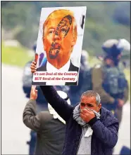  ?? (AP) ?? In this Feb 25, 2020 file photo, a Palestinia­n demonstrat­or covers his face from tear-gas fired by Israeli forces as he holds a poster of US President Donald Trump during a protest against Trump’s
Mideast initiative, in Jordan Valley in the West Bank.
