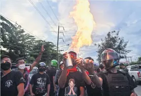  ?? AFP ?? Anti-government protesters create flames by lighting up aerosol cans during a demonstrat­ion in support of the release of political prisoners outside Bangkok Remand Prison on Wednesday.