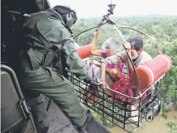  ??  ?? People are airlifted by the Indian Navy soldiers during a rescue operation at a flooded area. — Reuters photos