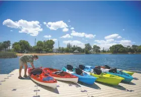  ??  ?? Left: Jesse Mando, of Fremont, kayaks on Lodi Lake. Right: Quin Murphy works on the dock. Headwaters Kayak has 1.5 to 2hour guided trips on the Mokelumne River.