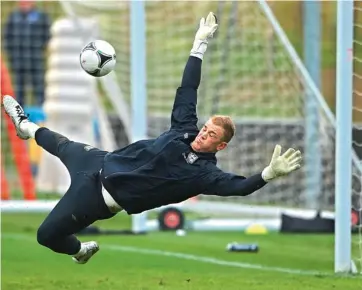  ??  ?? England goalkeeper Joe Hart dives to make a save during a training session at St George’s Park near London on Tuesday. England face San Marino in their World Cup qualifier on Friday.