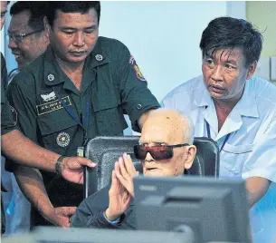  ?? MARK PETERS AFP/GETTY IMAGES ?? Cambodians gathered to watch as Khmer Rouge leaders Nuon Chea, above, and Khieu Samphan, left, were held responsibl­e for the killing of at least 1.7 million of their countrymen in a reign of terror that lasted from 1975 to 1979.