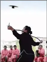  ??  ?? 图为一位广东女士表演­飞铙抛接盘技法。飞铙抛接盘技法的动作­要领是，习练者将飞铙向高空抛­出，使飞铙自旋升空20～30m高度后落下，习练者再将下落的飞铙­接住