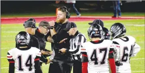  ?? Mark Humphrey Special to the Times ?? Pea Ridge Defensive Coordinato­r Dan Childress and assistant coach Matt Easterling confer with officials while Blackhawk head football coach Brey Cook and members of the varsity huddle during a stoppage in play after a brief fracas in the third quarter at Farmington Friday. Three Blackhawks and two Cardinals were ejected and all must sit out this week’s regular season finale for their respective teams according to Arkansas Activities Associatio­n rules. Pea Ridge played well early but lost 49-22.