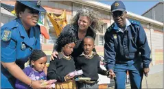  ?? Picture: DEON VAN DER WALT ?? SHOWING THEY CARE: Handing out donations of underwear to Soweto-on-Sea Primary School pupils are, from left, Warrant Officer Thembi Gwe, sponsor Tanya Steyn and Colonel Mzingisi Moshara. Happy pupils, from left, Elam Khasi, 4, Inam Makhitha, 5, and...