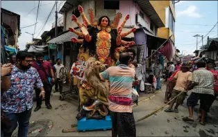  ?? ?? Laborers pull a clay idol of Hindu goddess Durga to load on a truck Sept. 26 ahead of Durga Puja festival at Kumortuli, the potters’ place, in Kolkata.