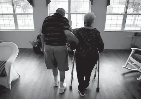  ?? AP Photo/Nam Y. Huh ?? In this June 30, 2017, file photo, an elderly couple walks inside an assisted living facility in Illinois. According to a study released on Oct. 1, a bone-strengthen­ing drug given intravenou­sly every 18 months greatly lowered the risk of fracture in certain older women. The results suggest these drugs may benefit more people than those who get them now and that they remain effective when used less often.