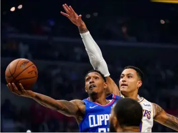  ?? AP Photo/Mark J Terrill, File ?? In this March 8 file photo, Los Angeles Clippers guard Lou Williams (left) shoots as Los Angeles Lakers forward Kyle Kuzma defends during the first half of an NBA basketball game in Los Angeles.