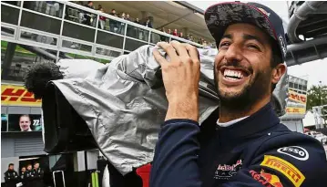  ?? — AP ?? Letting his hair down: Red Bull
driver Daniel Ricciardo of Australia playing with a camera during a stop due to heavy rain in the qualifying session in Monza on Saturday.