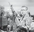  ?? JESSICA HILL/AP ?? Detective Barbara Mattson of the Connecticu­t State Police holds a Bushmaster AR-15.