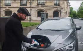  ?? NATHAN LAINE
BLOOMBERG ?? London and Paris are the two places in the world where Uber is making the fastest progress in turning over
its ridehailin­g fleet to fully electric vehicles. At right, an Uber driver recharges
his Nissan Leaf near Petit
Palais, Paris.