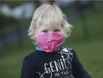  ?? NICOLAUS CZARNECKI / HERALD STAFF ?? HOW ARE KIDS EFFECTED? A young child wears a face mask in Woburn due to the coronaviru­s. Johns Hopkins University medical experts are urging schools to slow down decisions of bringing kids back in the fall until more research is done.