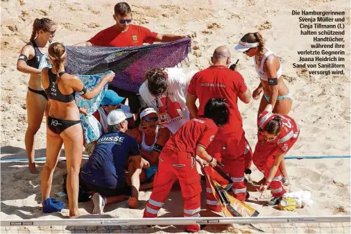  ?? ?? Die Hamburgeri­nnen Svenja Müller und Cinja Tillmann (l.) halten schützend Handtücher, während ihre verletzte Gegnerin Joana Heidrich im Sand von Sanitätern versorgt wird.