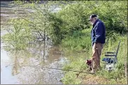  ??  ?? LEFT: William Lee of Adairsvill­e does a little fishing Friday in the Etowah River — which was too high for the planned canoe/kayak cleanup — while others were working to beautify the Neel’s Landing boat ramp off U.S. 411.