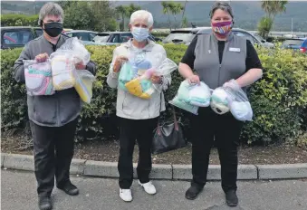  ?? 01_B39bonnets­01 ?? Knitter Margaret Auld adds a batch of knitted hats to the collection with Carol Harwood and Liz Maclean of Brodick Co-op.