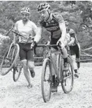  ??  ?? Some cyclocross racers choose to dismount rather than navigate a sand pit soaked with rain.