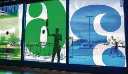  ?? PHOTOS BY TOM MCCARTHY JR. / FOR AMERICAN-STATESMAN 2017 ?? Juan Lopez wipes down the front doors at the 365 by Whole Foods in Cedar Park two days before it opened last year. The future of the 365 concept is uncertain after Austin-based Whole Foods was bought by Amazon.