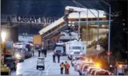  ?? ELAINE THOMPSON - THE ASSOCIATED PRESS ?? Lights illuminate cars from an Amtrak train that derailed above Interstate 5, Dec. 18, in DuPont, Wash. The Amtrak train making the first-ever run along a faster new route hurtled off the overpass Monday near Tacoma and spilled some of its cars onto...