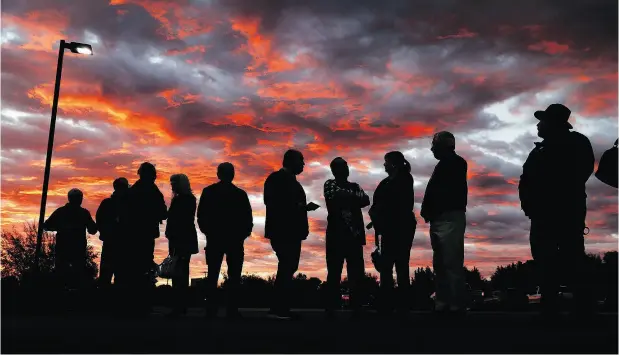  ?? MIKE SIMONS / TULSA WORLD VIA THE ASSOCIATED PRESS ?? Voters line up to cast their ballots shortly before the polls open in the midterm elections at First Church in Owasso, Okla., Tuesday.