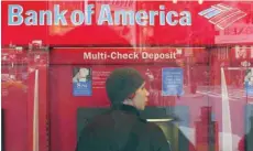  ?? — AFP ?? A Bank of America customer uses an ATM in Cambridge, Massachuse­tts.