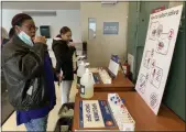  ?? TANIA BARRICKLO — DAILY FREEMAN ?? SUNY New Paltz freshmen Jayla Ash, left, and Nathaly Perez swab their mouths for saliva COVID tests on Jan. 25 in the basement of the Awosting Hall dormitory on campus.