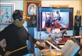  ?? Hector Vivas Getty Images ?? TEACHING MUSIC remotely is a challenge for instructor­s, who rely on handson classes. Above, Musician Jose Gurria teaches drums in Mexico City on May 5.