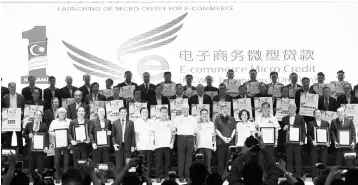  ?? — Bernama photo ?? Najib (centre) poses for a phototakin­g session with representa­tives of organisati­ons and associatio­ns during the launch of the Micro Credit E-Commerce scheme at Wisma Huazhong.