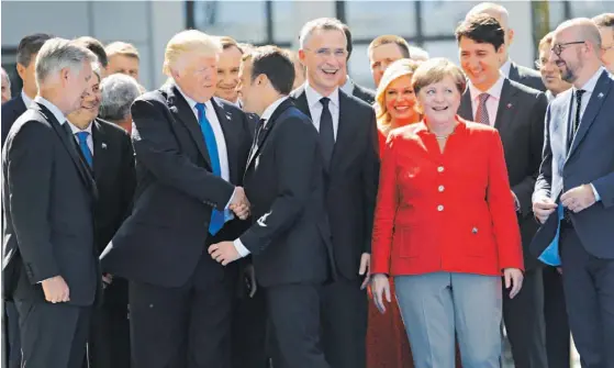  ??  ?? Trump e Macron repetiram o aperto de mão do encontro bilateral, mas agora rodeados dos restantes líderes da NATO. Mais cedo, o presidente americano reunira-se com Donald Tusk e Jean-Claude Juncker. Durante a cimeira, as primeiras-damas visitaram o...