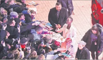  ?? — AFP photo ?? Nyong‘o signs autographs as she arrives on the red carpet prior to the opening ceremony of the 74th Berlinale, Europe’s first major film festival of the year, in Berlin.