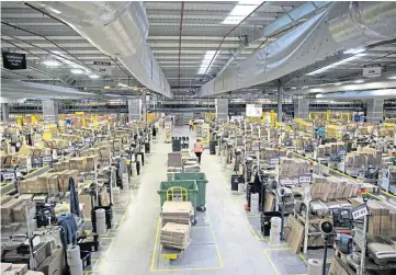  ??  ?? NO BONUS: Parcel packing at Amazon’s massive Dunfermlin­e fulfilment centre.