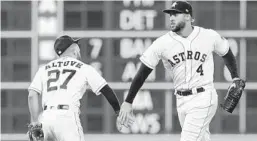  ?? TIM WARNER/GETTY-AFP ?? left, celebrates with George Springer after the Astros’ victory over the A’s.