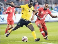  ??  ?? Jamaica’s Je-Vaughn Watson (left) fights for the ball against Canada’s David Junior Hoilett during the second half of an internatio­nal friendly football match on Saturday at the BMO Field in Toronto.