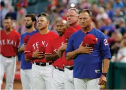  ?? Associated Press ?? Texas Rangers manager Jeff Banister, right, staff and players stand during the playing of the national anthem before a baseball game against the Oakland Athletics on Sept. 28 in Arlington, Texas.