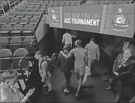  ?? Associated Press ?? Attempt to save March Madness: Clemson players leave the floor after the NCAA college basketball games at the Atlantic Coast Conference Tournament were canceled due to concerns over the coronaviru­s Thursday in Greensboro, N.C.