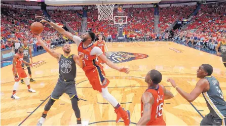  ?? GERALD HERBERT/ASSOCIATED PRESS ?? New Orleans’ Anthony Davis, center, tries to block the shot by Stephen Curry (30) during the second half of the Pelicans’ win over Warriors.