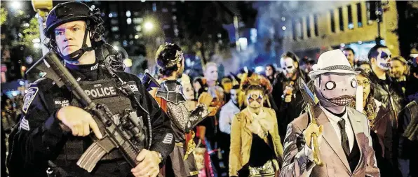  ?? KUDACKI ?? Schwer bewaffnete Polizisten sichern in New York eine Halloween-Parade. Nach dem Anschlag wurde die Alarmberei­tschaft noch einmal erhöht.DPA-BILD: