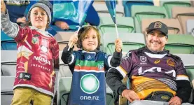  ?? Photo / Ian Cooper ?? The mighty front row - a young Warriors fan propped by the two from the Broncos.