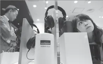  ?? BLOOMBERG ?? A customer tries a Harman Internatio­nal Industries Inc’s JBL branded speaker at Harman store in Tokyo, Japan.