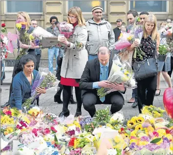  ??  ?? Council staff move floral tributes from Albert Square to St Ann’s Square for a vigil last night