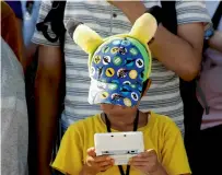  ?? Reuters ?? A boy plays on Nintendo’s game console prior to a parade where Pokemon’s character Pikachu attended in Yokohama. —