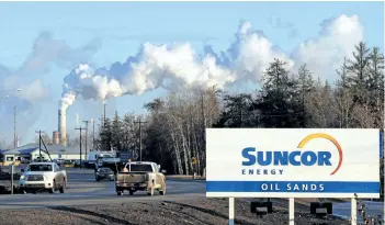  ?? GETTY FILES ?? Workers leave the Suncor oilsands extraction facility near the town of Fort McMurray, Alta. Suncor recorded a secondquar­ter loss due to the wildfires that ravaged Fort McMurray in May.